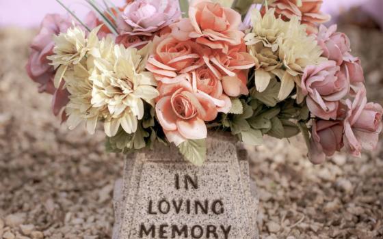 Flowers and a sign that says "In loving memory"