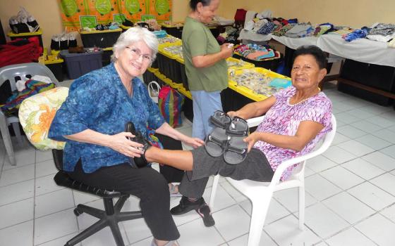 Sr. Annie Credidio helps a patient try on shoes at Damien House in Guayaquil, Ecuador, which treats people with leprosy. Credidio won $100,000 as a finalist for the 2022 Opus Prize. (Courtesy of Damien House)