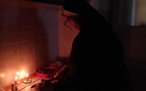 A Basilian sister prepares food by candlelight in Ukraine. As Basilian Sr. Yeremiya Steblyna writes, "The Ukrainian people have entered a time of blackout." (Courtesy of Yeremiya Steblyna)