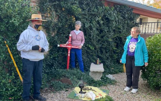 Deacon Gabriel Saspe of Douglas, Arizona, left, invites participants — including Sr. Anita Fearday, center, of the Adorers of the Blood of Christ and Sr. Lucy Nigh of the School Sisters of Notre Dame — to pray at the planting of a memorial cross for Ireny Perez Escalante in the columbaria of St. Andrew the Apostle Catholic Church in Sierra Vista, Arizona. (Peter Tran)