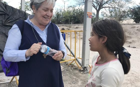 Sr. Norma Pimentel, director of Catholic Charities of the Rio Grande Valley in Texas, speaks with a young resident of a tent camp Feb. 29, 2020, in Matamoros, Mexico. (CNS/David Agren)