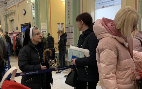 Sr. Lucja Kwasniak, a member of the Sisters, Servants of the Immaculate Heart of Mary, talks to Ukrainian refugees April 21 at the train station in Przemysl, Poland.