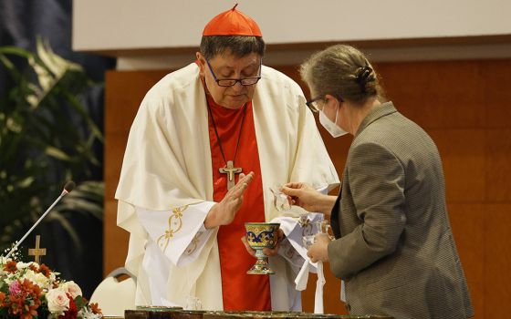Cardinal João Braz de Aviz is assisted by Comboni Sr. Gabriella Bottani during a May 3 Mass with superiors of women's religious orders at the plenary assembly of the International Union of Superior Generals in Rome. (CNS/Paul Haring)