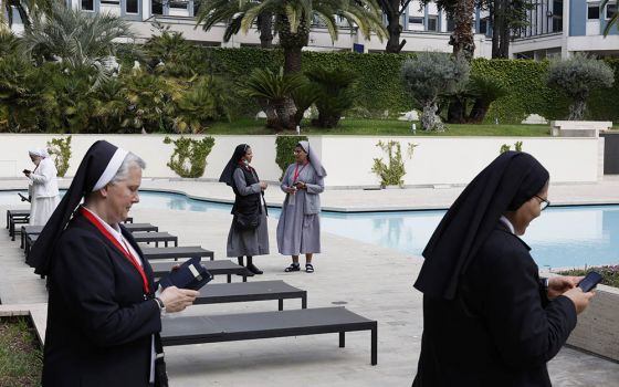 Nuns talk and use their phones during a break as superiors of women's religious orders meet for the plenary assembly of the International Union of Superior Generals in Rome May 3. (CNS/Paul Haring)