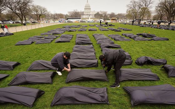 Body bags are placed on the National Mall in Washington near the U.S. Capitol on March 24. (CNS/Reuters/Kevin Lamarque)