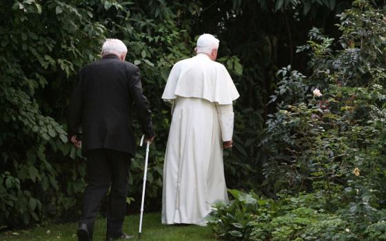 Pope Benedict and his brother walk in a park