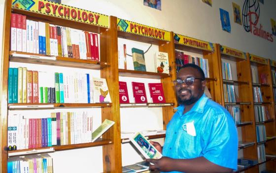 Man holds book in bookstore.