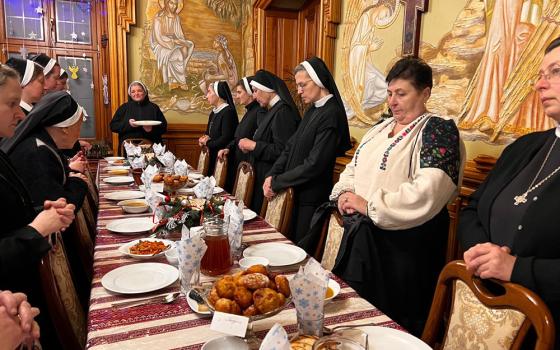 The Basilian sisters community in Ukraine is pictured at the beginning of "Holy Eve," the evening before Christmas, after a day of fasting until dinner. Here the superior gives Christmas greetings to the sisters. (Courtesy of Yeremiya Steblyna)