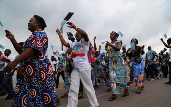 Women wave Congolese flags during a march to protest escalating violence in Congo, in Kinshasa Dec. 4, 2022. (CNS/Reuters/Justin Makangara)