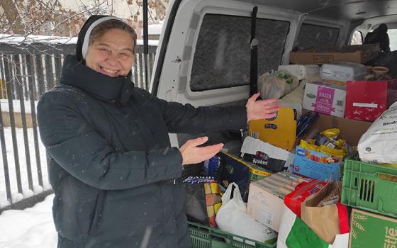 Polish Sr. Renata Jurczak gestures to a van full of supplies in the snow