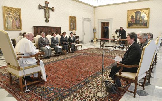 Pope Francis sits with a group of women in a semicircle