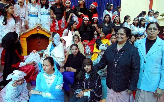 Ursuline Sr. Tisy Jose (second from right) and Sr. Ranjana Thomas (right), principal of Mariampur School in Kanpur, India, celebrate with students Christmas as the festival of life on Dec. 22, 2022. (Courtesy of Tisy Jose)