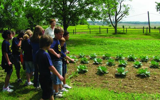 Ursuline Sr. Amelia Stenger teaches students from Sts. Peter and Paul School in Hopkinsville, Kentucky, about growing a garden sustainably on the grounds of the Mount St. Joseph motherhouse in Daviess County. (Courtesy of Ursuline Sisters of Mount St. Joseph)