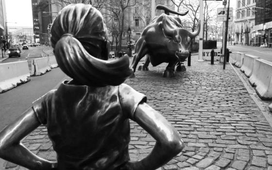 Fearless Girl statue, which depicts a girl with a pony tail and hands on hips, faces the Charging Bull statue in New York's Financial District.