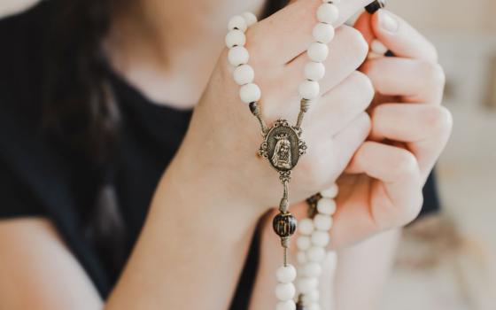 closeup of woman holding a rosary