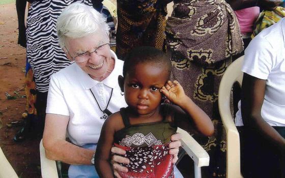 Sr. Kathleen Feeley of the School Sisters of Notre Dame holds a child at a village meeting in a small village near Sunyani, Ghana. (Courtesy of Kathleen Feeley)