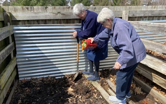 Srs. Marge Clifford and Judy Warmbold add the Daughters of Charity's weekly contributions to the parish compost garden, at Holy Spirit Parish in Maryland Heights, Missouri. In this edition of The Life, panelists discuss their actions to address the climate crisis. (Courtesy of Honora Remes)