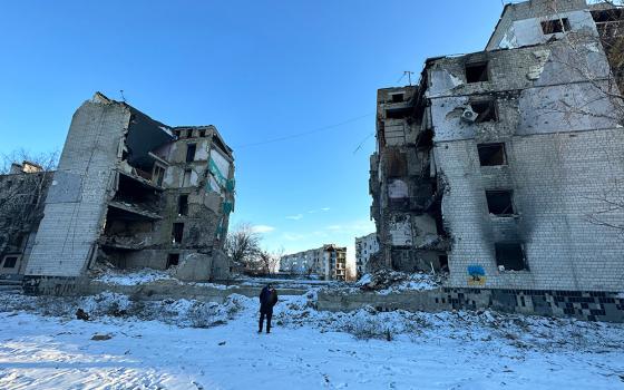 GSR's Chris Herlinger, in the center, walks near the center of an apartment complex in Borodyanka, Ukraine, which collapsed when it was hit by a Russian missile on April 5, 2022. (GSR photo/Gregg Brekke)