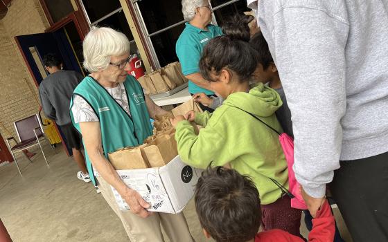 Notre Dame Sr. Roseanna Mellert and others hand out food to migrants at La Frontera's annex in Laredo, Texas. (Luis Donaldo Gonzalez)