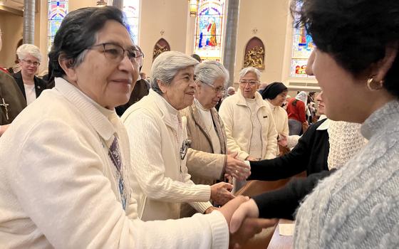 Sr. Rosa Cruz of the Guadalupan Missionaries of the Holy Spirit gives the sign of peace to Leslie Bocanegra, a young woman invited to attend the Mass to celebrate the World Day of Consecrated Life at St. Paul's Cathedral in Birmingham, Alabama. (Courtesy of Maria Elena Méndez Ochoa)