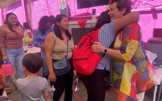 St. Joseph of Carondolet Sr. Suzanne Jabro receives a hug from a woman at the Cobino shelter in Mexicali, Mexico May 10, when women religious arrived to mark Mother's Day. The visit came a day before the U.S. lifted a public health measure that kept migrants from applying for asylum during the coronavirus emergency. (GSR photo/Rhina Guidos)