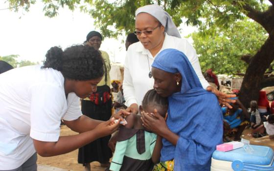 Patience Iremiah, 9, receives the first of three HPV vaccine doses in the New Kuchingoro IDP Camp in Abuja, Nigeria, on March 25. The vaccine protects against infections and cervical precancers. (GSR photo/Valentine Benjamin) 