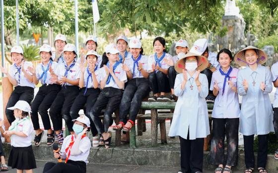 Filles de Marie Immaculée Srs. Mary Elizabeth Tran Thi Bich Diep (first from right) and Mary Vu Thi Thuy Anh (third from right) spark young women's interests in religious vocations by playing outdoor games with them at Xuan Thien Parish in Hue, Vietnam, April 23.