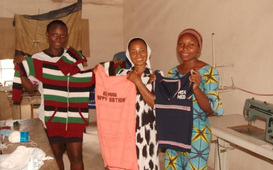 Sr. Lydia Agba and students at the Women’s Empowerment Center display clothes they knitted. (GSR photo/Valentine Benjamin)