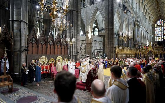 King Charles III sits as he is crowned with St. Edward's Crown by Archbishop of Canterbury Justin Welby during the coronation ceremony at Westminster Abbey, London, May 6. (Jonathan Brady/Pool Photo via AP)