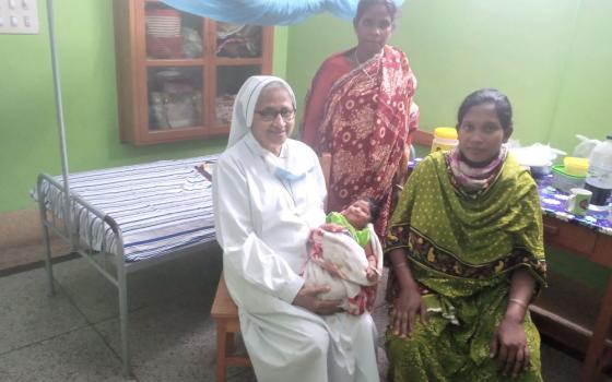 Sr. Sandra Joseph, a member of Sisters of Charity of Sts. Bartolomea Capitanio and Vincenza Gerosa, visits a newborn baby and their relatives at St. Vincent Hospital in Dinajpur, Bangladesh, where she has ministered for 42 years. (Sumon Corraya)