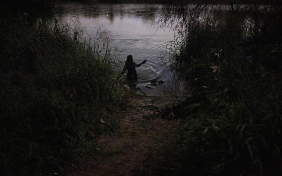  An unaccompanied minor from Honduras wades across the Rio Grande headed for Roma, Texas, May 13, 2022. (CNS/Reuters/Adrees Latif)