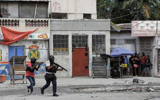 Police officers hold their position as they take part in an anti-gang operation amid gang violence March 3 in Port-au-Prince, Haiti. U.N. human rights expert William O'Neill, who was appointed to assess the situation in Haiti in April, told reporters June 28 that a "specialized international force" is needed to help fight gang violence ravaging the impoverished Caribbean nation. (OSV News/Reuters/Ralph Tedy Erol)