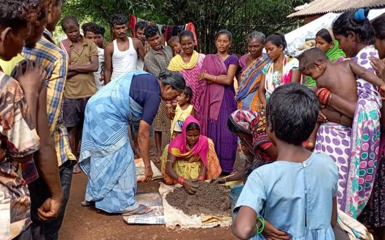 Sister Lisha demonstrates the method of organic manure composition to villagers. (Courtesy of Tessy Jacob)