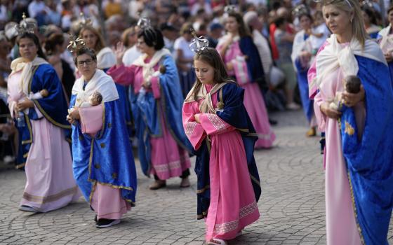 Women and girls dressed in pink and blue like the Virgin statue and carrying Jesus dolls, take part in the Our Lady of Remedies procession in the small town of Lamego, in the Douro River Valley, Portugal, Friday, Sept. 8, 2023. One of Portugal's largest and oldest religious festivals, the two-week celebrations that culminate with the procession, draw thousands. (AP Photo/Armando Franca)