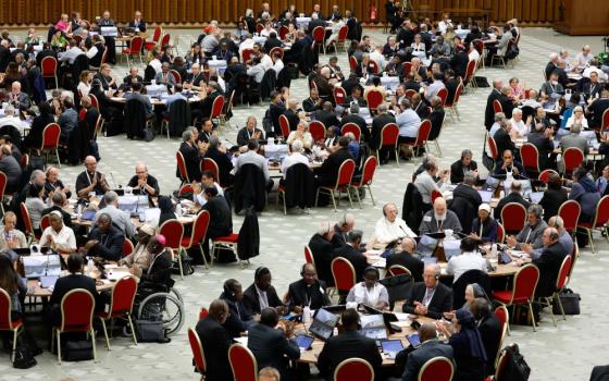 People sit around several round tables