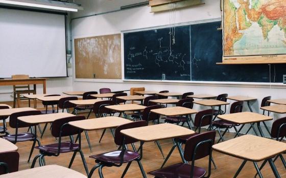 Blackboard and big map are visible in an empty classroom.