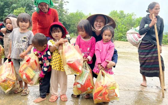 Ethnic Van Kieu children whose parents died of or were injured by ordnance left from wars receive gifts from Missionaries of Charity Sr. Margaret Vu Yen Nhung (wearing a conical hat) on Sept. 24 at Vinh Ha village in Quang Tri province. "This is the first time we offer gifts to the children who have no chance to get gifts to celebrate the festival because their parents have no money," Nhung said. (GSR photo/Joachim Pham)