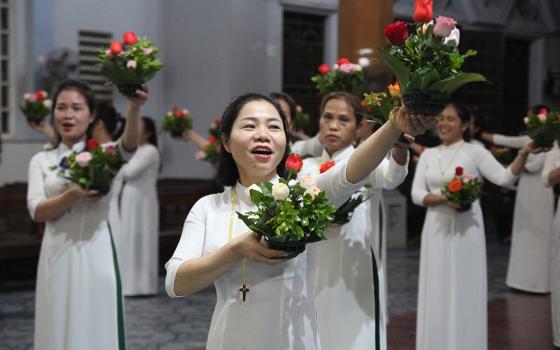 Mary Nguyen Thi Thu Huong (center) said three sisters were helping them to perform dang hoa on the evenings of Wednesdays and Saturdays in October in the Diocese of Hung Hoa, Vietnam. "Dang hoa aims at encouraging local people to recite the rosary regularly and to pray for the evangelization work in the diocese," said the 35-year-old mother of two, who has joined the troupes for six years. (GSR photo/Joachim Pham)