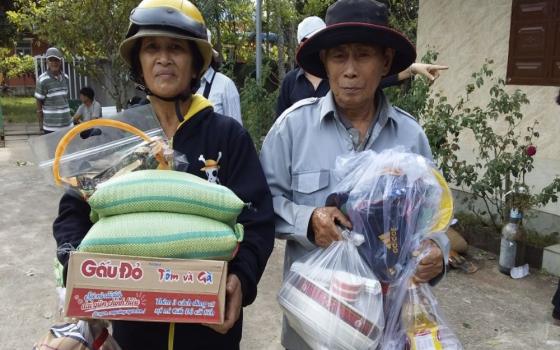 Two women wearing hats carry bags