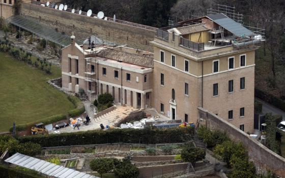 An aerial view of a building with a short tower and a shorter wing. It appears there is construction or renovation in progress.