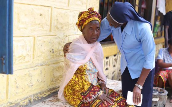 Sr. Victoria Amie Tholley, a member of Sisters of St. Joseph of Cluny, consoles Nana Kamara on Sept. 20.