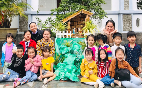 Daughters of Our Lady of the Visitation Sr. Mary Truong Thi Danh (left), a teacher and children pose for a photo at Phu Vang convent on Dec. 9 