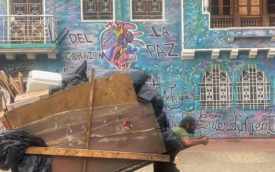 A man pulls a cart of recycled material past a mural that says "From the heart comes peace" in Bogotá, Colombia, Nov. 22. Though 2016 peace accords put an end to the decadeslong conflict between the Revolutionary Armed Forces of Colombia (FARC) and the government, Colombia's poorest, many in rural communities, still suffer violence, said Dominican Sr. Diana Herrera Castañeda. (GSR photo/Rhina Guidos)
