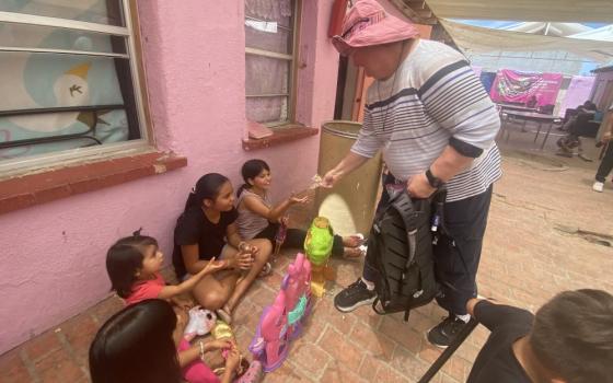 Sr. Lisa Buscher, of the Society of the Sacred Heart, shares candy with children at a migrant shelter in Mexicali, Mexico on May 9.