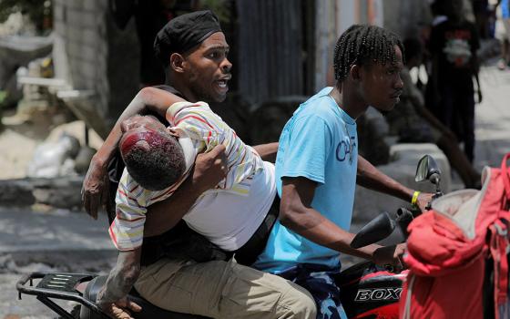 People take a wounded man to a hospital in Port-au-Prince, Haiti, Aug. 15, 2023, after gangs took over their neighborhood Carrefour-Feuilles. Vatican News reported Jan. 19, 2024, that armed men in Port-au-Prince took over a bus and kidnapped at least six nuns and others who were on the bus. The gunmen, who drove off with them to an unknown destination, were not immediately identified but authorities suspected they were gang members. (OSV News/Reuters/Ralph Tedy Erol)