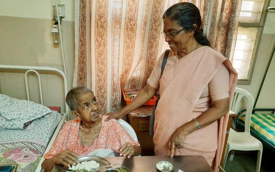 Sr. Stella Baltazar visits a sister admitted to a special facility for infirm nuns attached to a hospital managed by her congregation, the Franciscan Missionaries of Mary, in Coimbatore, Tamil Nadu state, India. (Saji Thomas)