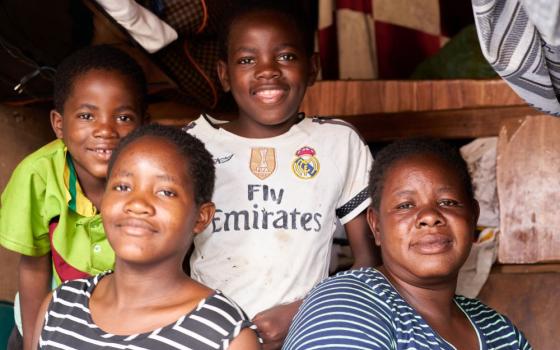 Mary Liawe and her three children pose in their apartment in the Matapi hostel in Harare, Zimbabwe.