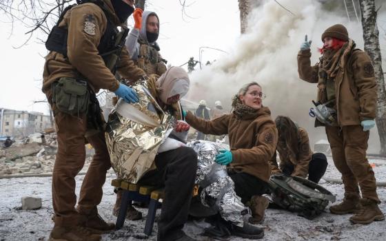 Emergency personnel treat a wounded resident of an apartment building in Kharkiv, Ukraine, that was heavily damaged in a Russian missile attack on Jan. 23. 