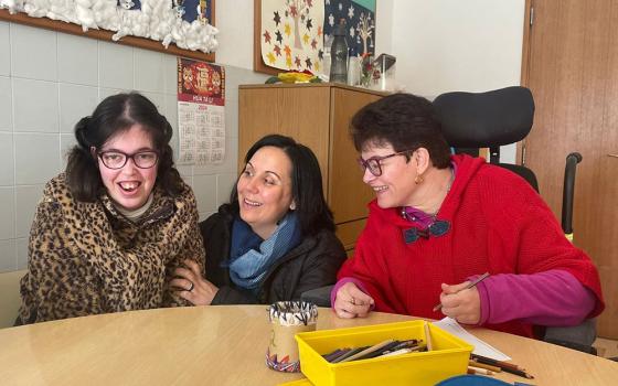 Sr. Ana da Paz Nunes (center), of the Franciscan Sisters of Divine Providence, interacts with two residents of the House of the Good Samaritan in Fátima, Portugal. One of the daily activities at the house is painting and drawing. (GSR photo/Leopoldina Reis Simões)