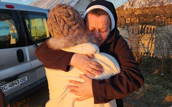 Sr. Lucia Murashko, a member of the Order of St. Basil the Great, hugs a resident of the village of Orihiv, eastern Ukraine, during a delivery of humanitarian supplies earlier this month. (GSR photo/Chris Herlinger)